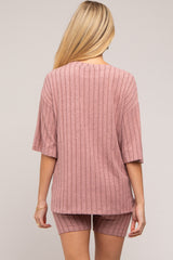 woman wearing a dusty rose ribbed maternity top and matching shorts, viewed from the back