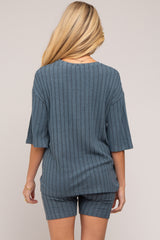 woman wearing a blue ribbed maternity loungewear set with short sleeves and shorts, showing her back