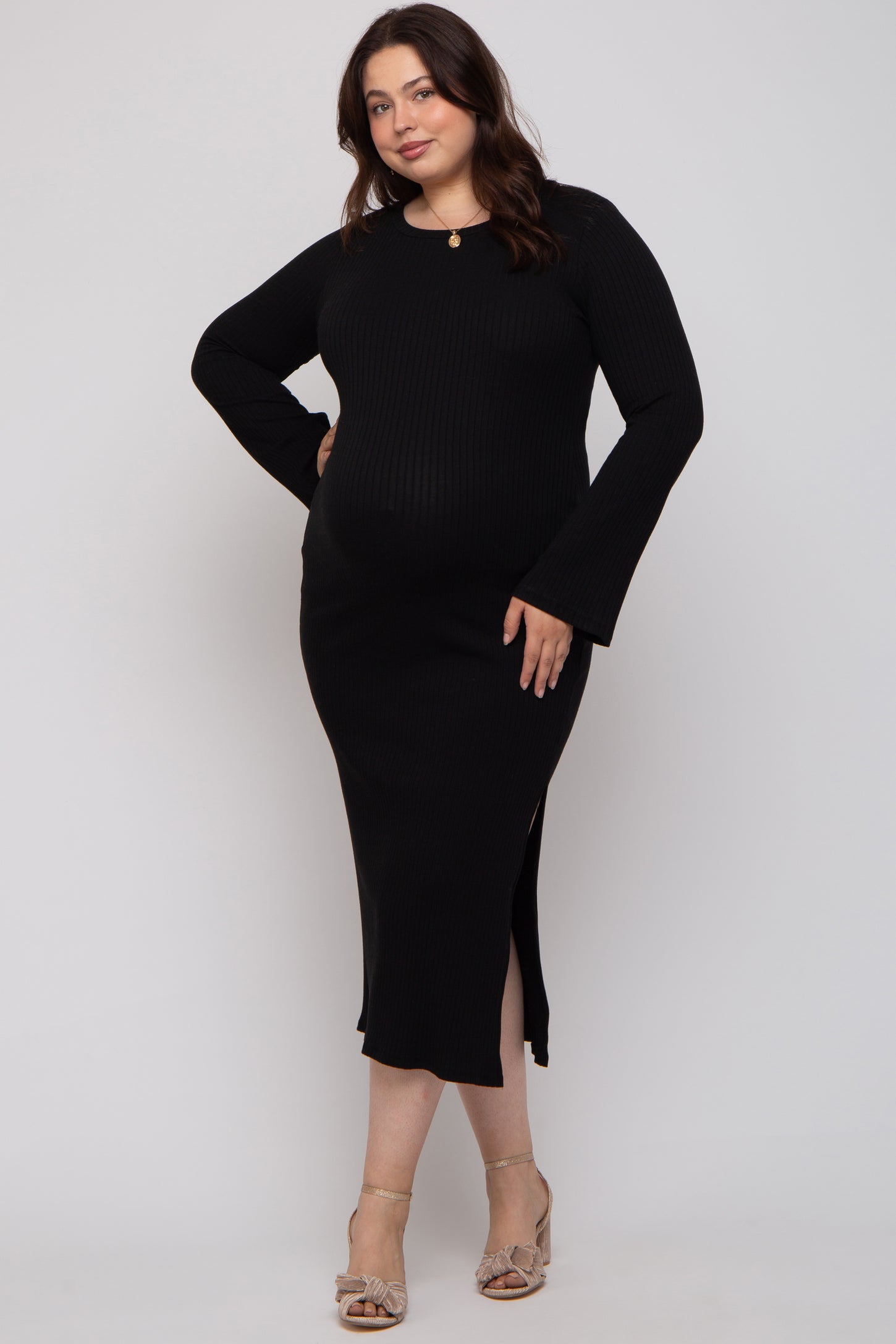 woman wearing a black ribbed long sleeve maternity dress with side slits and a visible baby bump