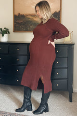 woman wearing a burgundy ribbed maternity dress with a side slit and showing her baby bump