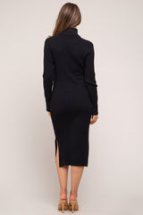 woman wearing a black ribbed maternity dress with a high neckline and side slit, showing a pregnant baby bump