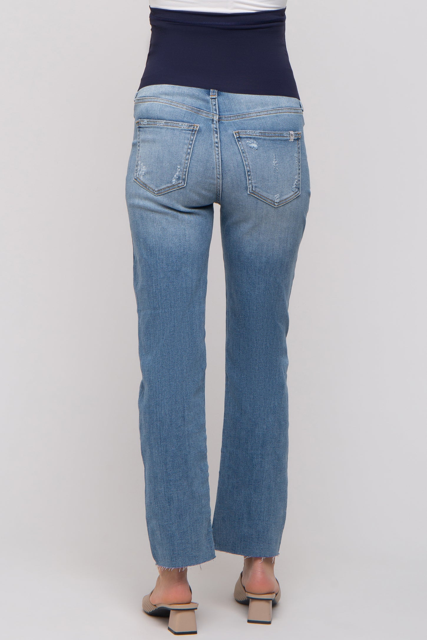 woman wearing light blue maternity jeans with a stretchy navy waistband, shown from the back
