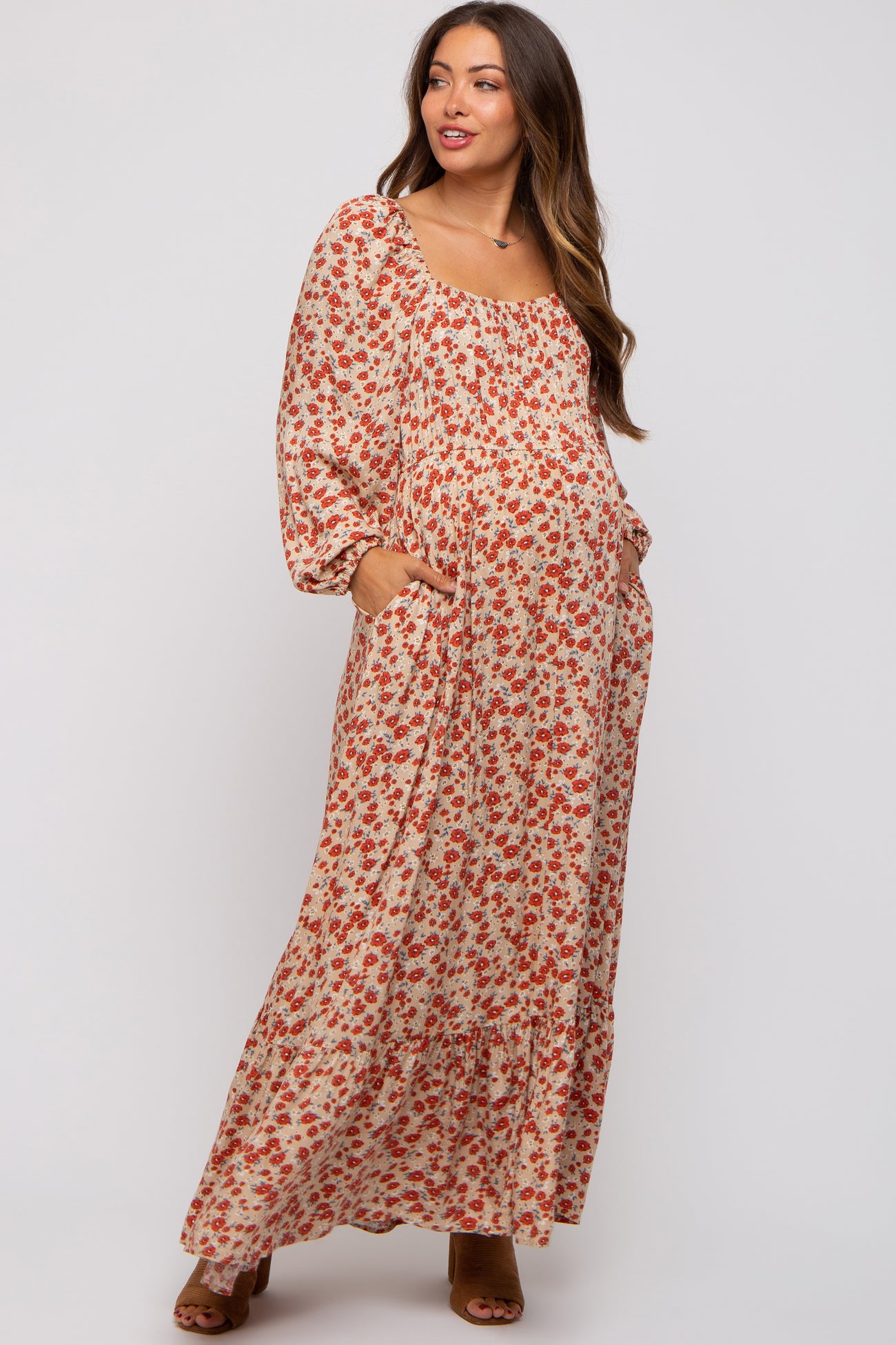 woman wearing a floral print maternity maxi dress with a square neckline and long puff sleeves, baby bump visible
