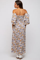 woman wearing a floral off-the-shoulder maternity dress with puff sleeves, showing a relaxed fit and a long length