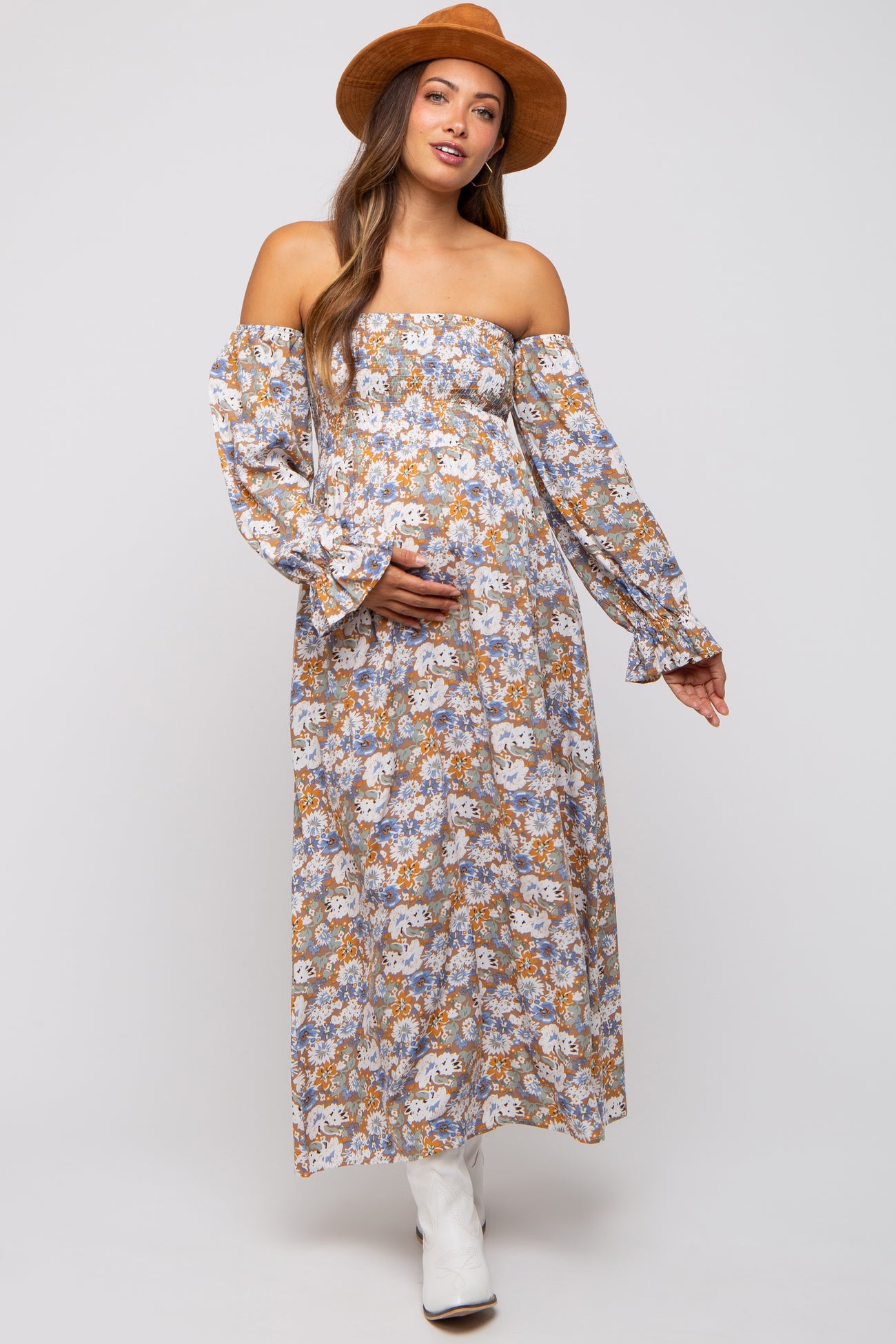 woman wearing a floral off-the-shoulder maternity maxi dress and holding her baby bump