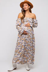 woman wearing a floral off-the-shoulder maxi maternity dress with long sleeves and a baby bump visible