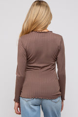woman wearing a brown ribbed long sleeve maternity top with a frilled hem and back detail