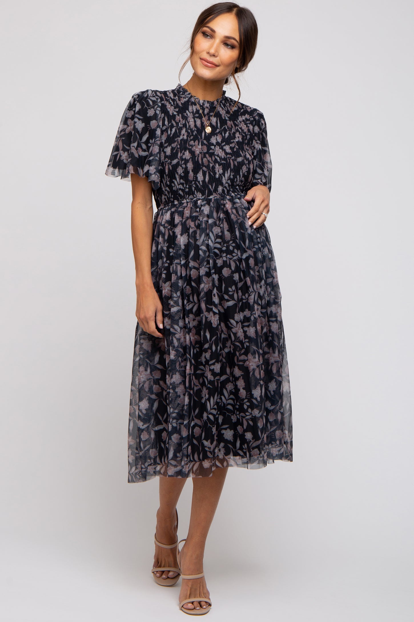 woman wearing a navy blue floral maternity dress with short puff sleeves and a gathered waist