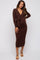 woman wearing a brown long sleeve maternity dress with a deep v-neck and tie detail, showing her baby bump