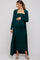 woman wearing a dark green maternity dress with a long cardigan, showing baby bump and styled with sandals