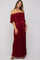 woman wearing a burgundy off-the-shoulder maternity dress with ruffle detail and a visible baby bump