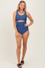 woman wearing a navy blue two-piece swimsuit with ruffle details and a high-waisted bottom