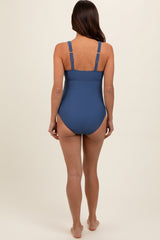 woman wearing a blue maternity swimsuit with adjustable straps, showing the back view