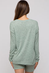 woman wearing a green ribbed maternity lounge set, view from the back showing long sleeves and shorts
