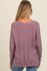 woman wearing a mauve oversized maternity sweater with a relaxed fit and ribbed hem, showing the back view