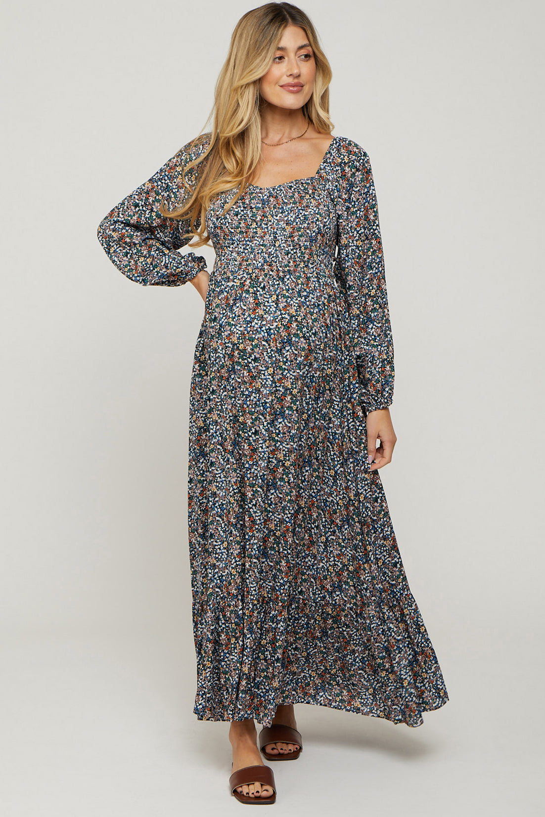 woman wearing a floral maternity maxi dress with long sleeves and a square neckline, showcasing her baby bump