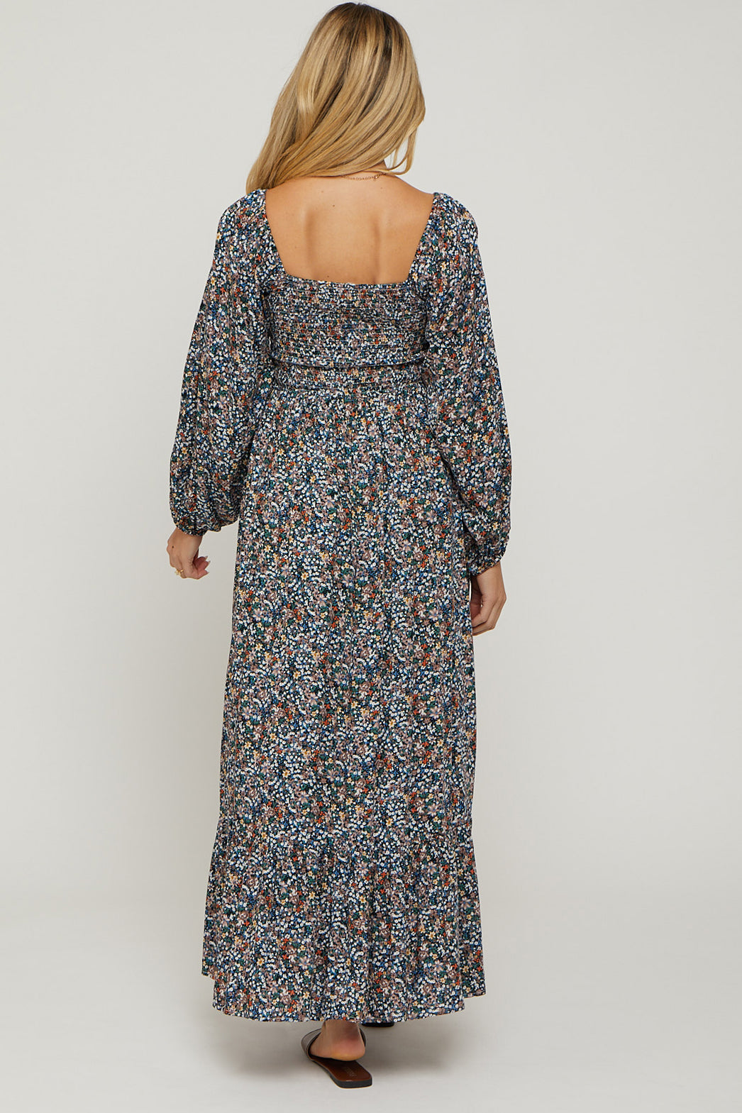 woman wearing a floral print long sleeve maternity maxi dress with a square back and puffed sleeves