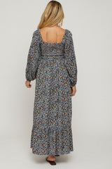 woman wearing a floral print long sleeve maternity maxi dress with a square back and puffed sleeves
