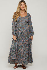 woman wearing a floral long sleeve maternity dress with a square neckline and a flowing skirt, highlighting her baby bump
