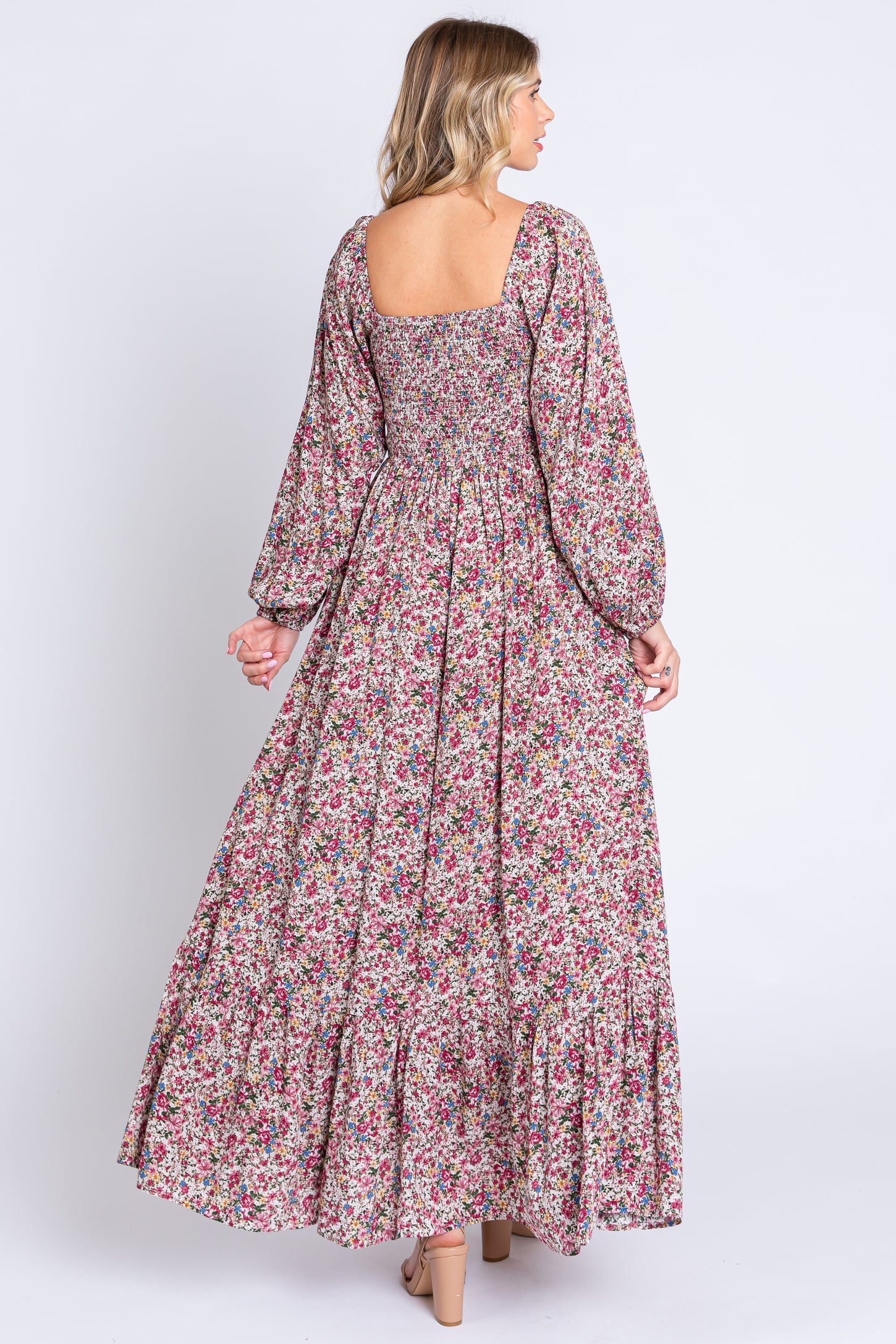 woman wearing a floral maxi dress with square back and balloon sleeves, featuring a tiered skirt