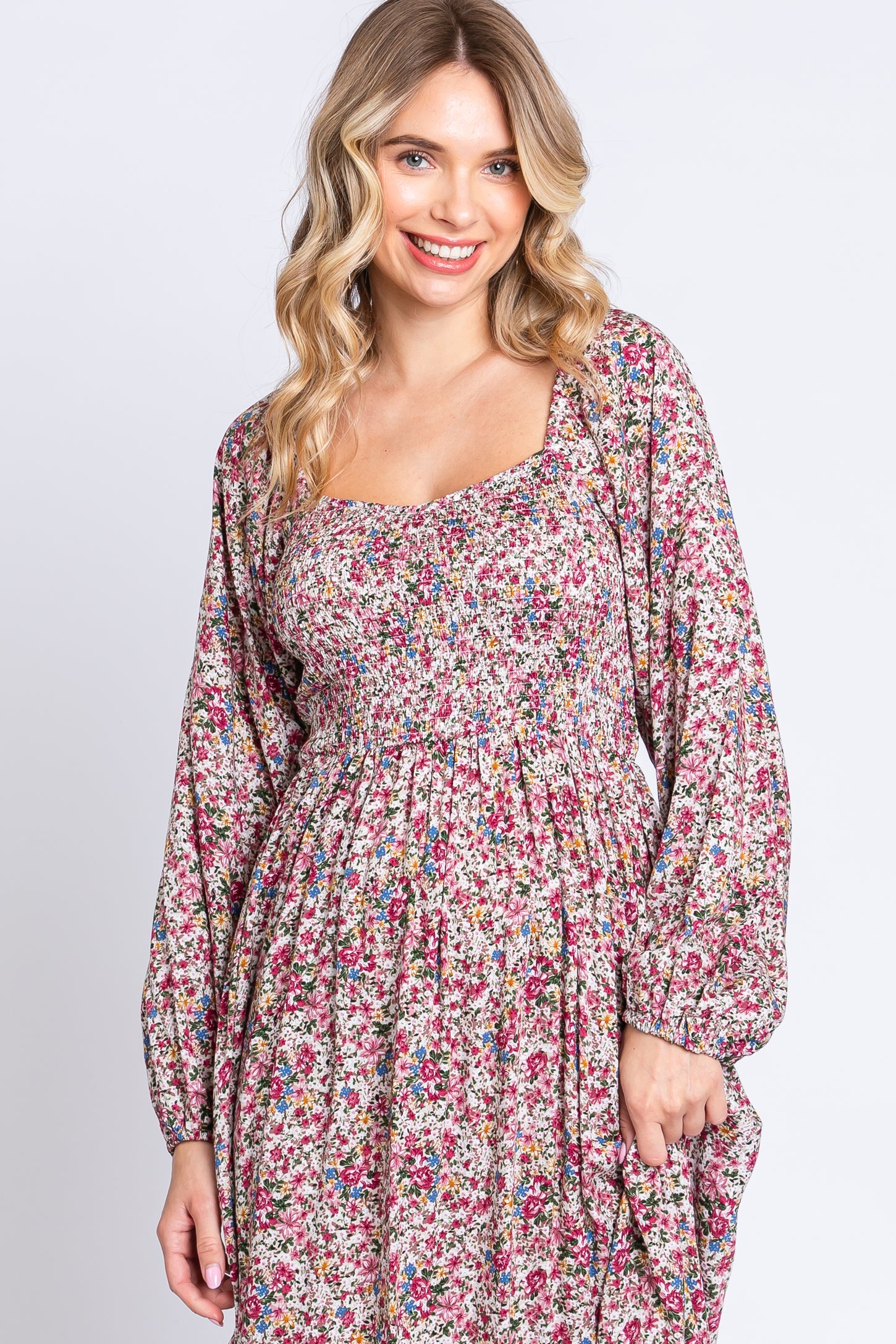 woman wearing a floral print long sleeve maxi dress with a square neckline and smocked bodice