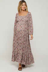 woman wearing a floral print maxi maternity dress with long sleeves and a visible baby bump