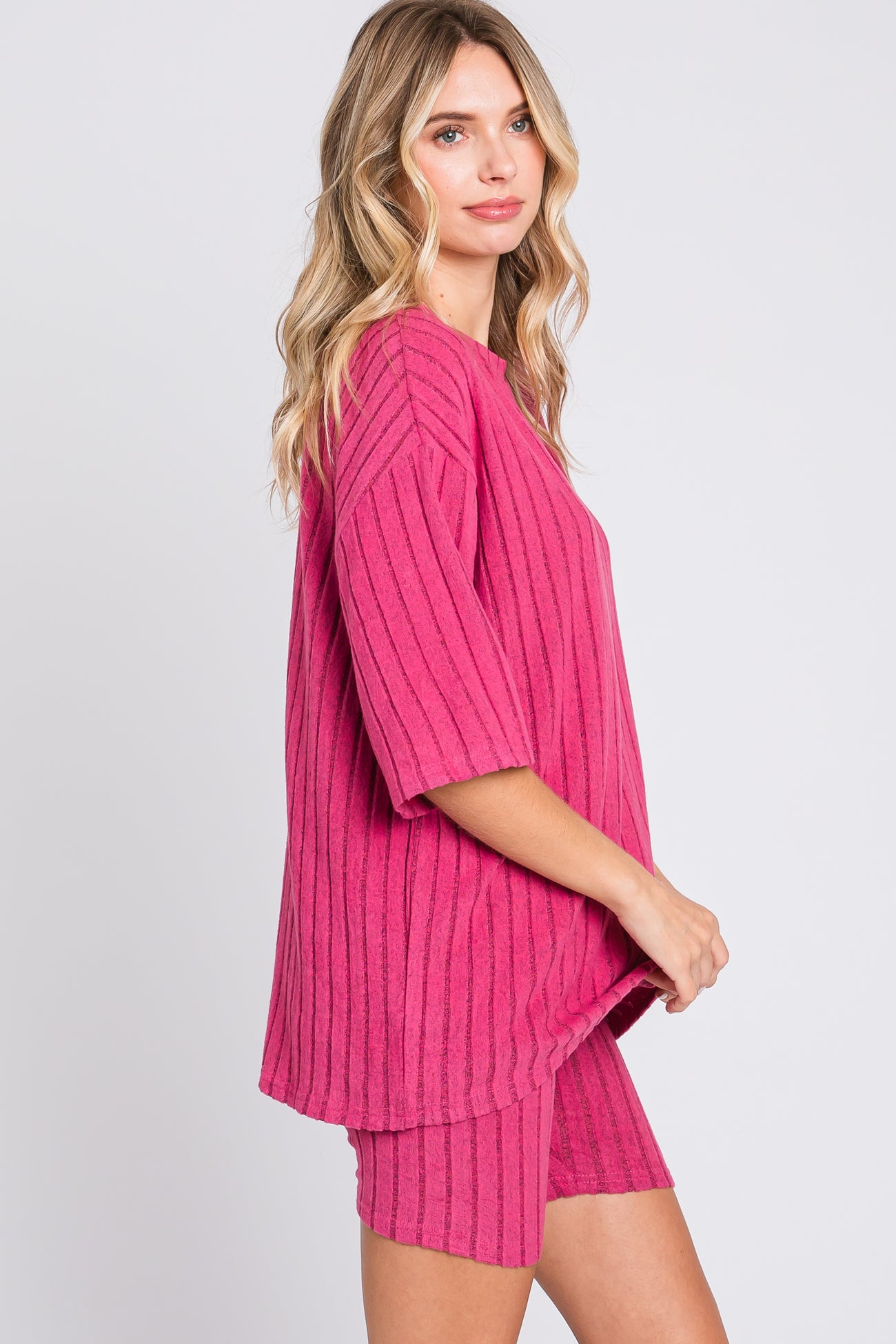 woman wearing a pink striped oversized top with short sleeves and matching pink shorts