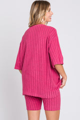woman wearing a bright pink oversized ribbed top and matching shorts, view from the back