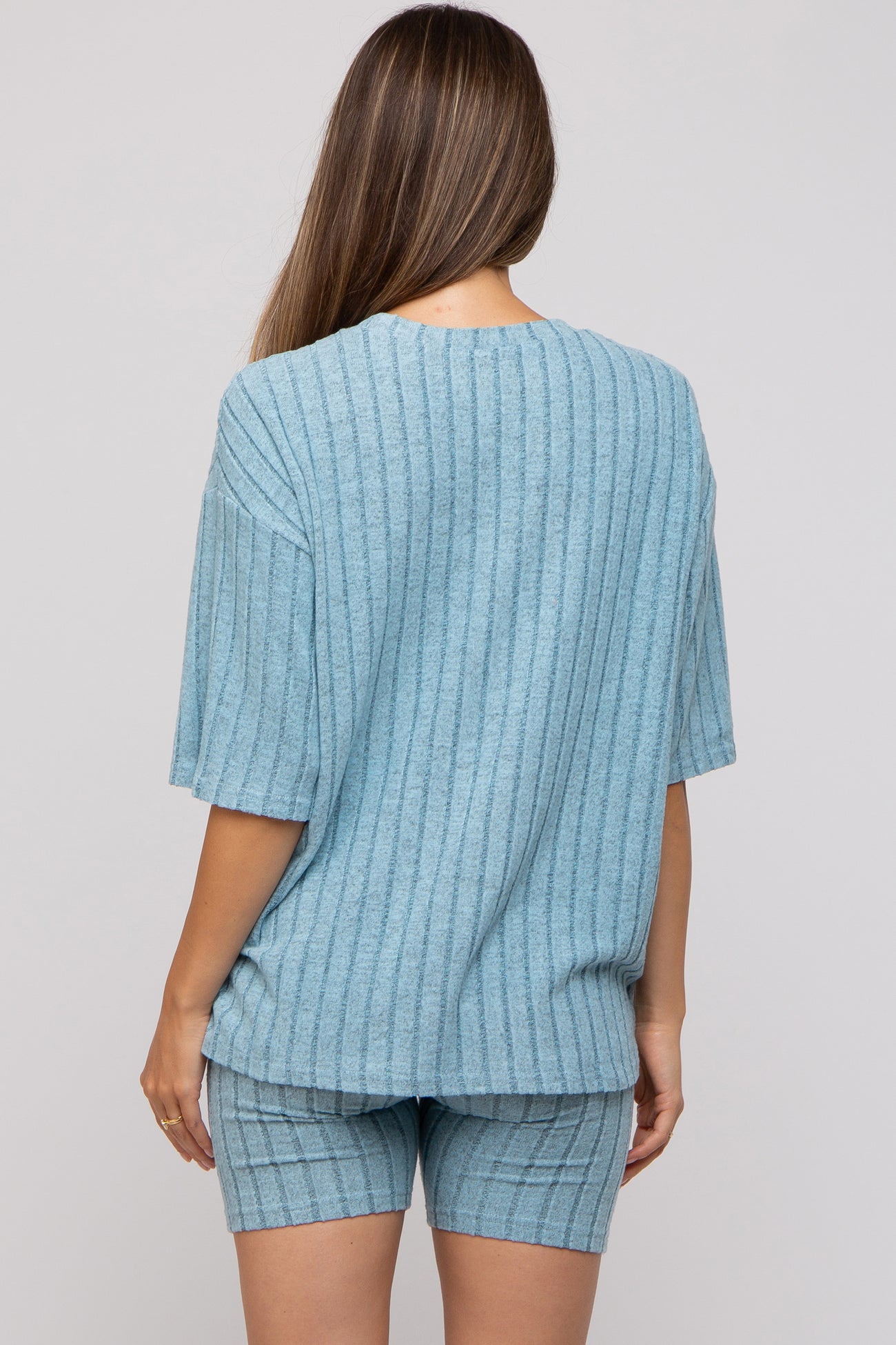 woman wearing a light blue maternity loungewear set with a ribbed short sleeve top and matching shorts