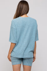 woman wearing a light blue maternity loungewear set with a ribbed short sleeve top and matching shorts