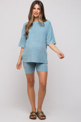 woman wearing a light blue ribbed maternity short set with a visible baby bump