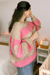 woman wearing a beige and pink striped oversized sweater with long sleeves and a casual hairstyle
