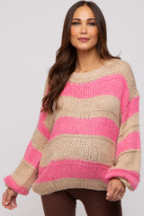 woman wearing a striped pink and beige oversized maternity sweater with a relaxed fit and visible baby bump