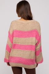 woman wearing a beige and pink striped oversized maternity sweater, showing the back view