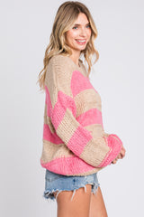 woman wearing a beige and pink striped oversized sweater with long sleeves and denim shorts