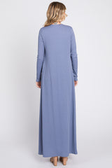 woman wearing a ribbed long sleeve maxi dress in soft blue, showing the back view with a flowy silhouette.