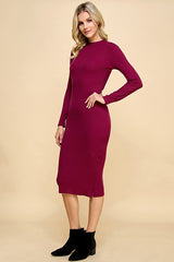 woman wearing a burgundy long sleeve fitted ribbed dress with buttons along the hemline and ankle boots