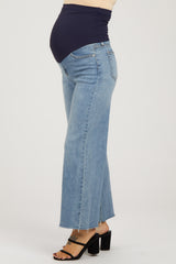 woman wearing light blue maternity wide-leg jeans with a dark blue belly panel and a visible baby bump
