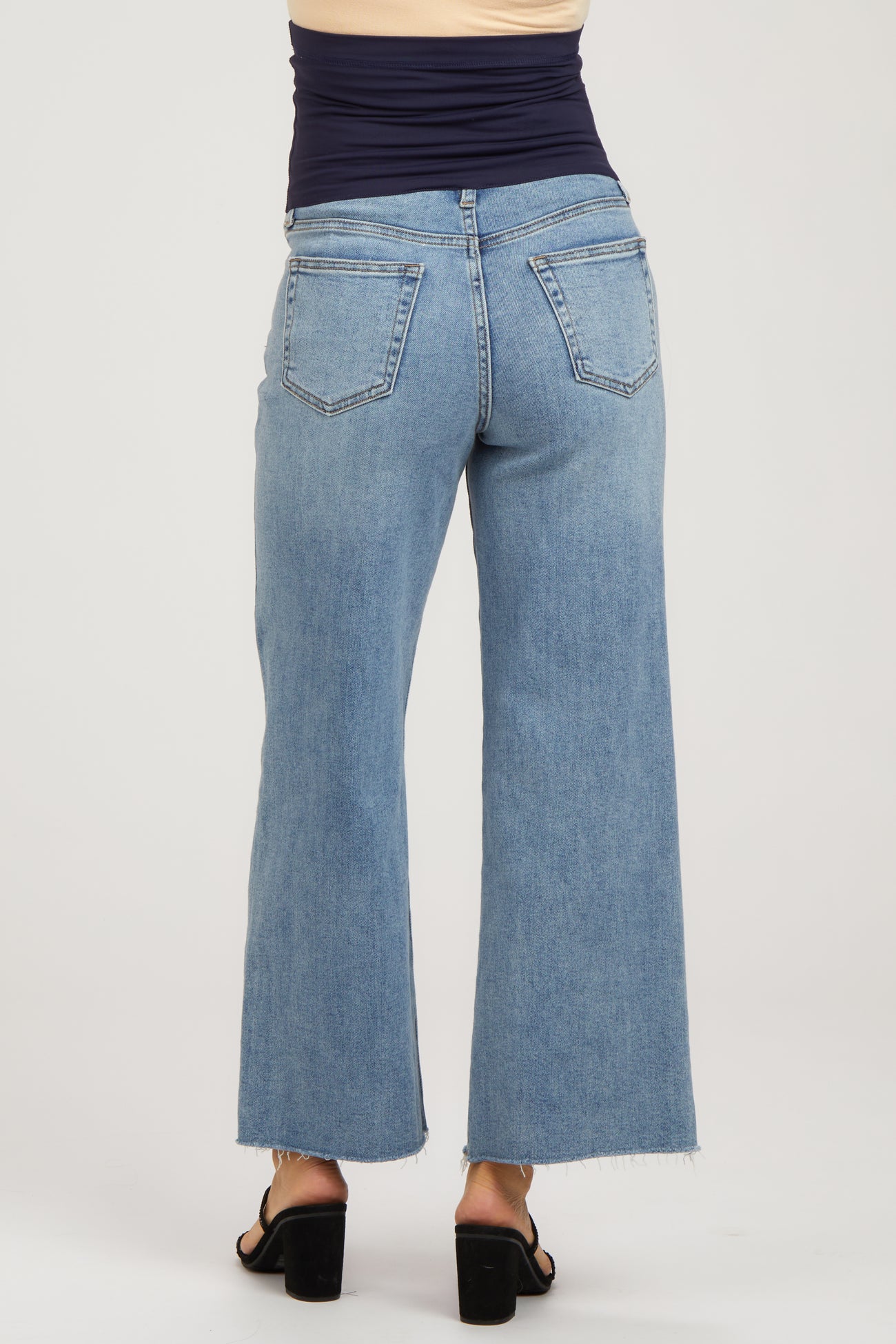 woman wearing light blue maternity wide-leg jeans with a frayed hem, shown from the back