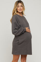 woman wearing a gray long sleeve maternity dress with puffed sleeves and a visible baby bump