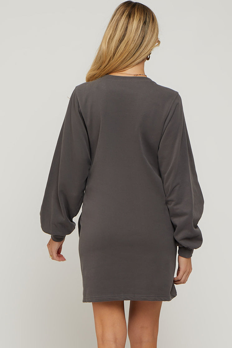woman wearing a dark gray maternity sweater dress with long balloon sleeves, showing the back view