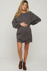 woman wearing a dark gray maternity sweatshirt dress and holding her baby bump