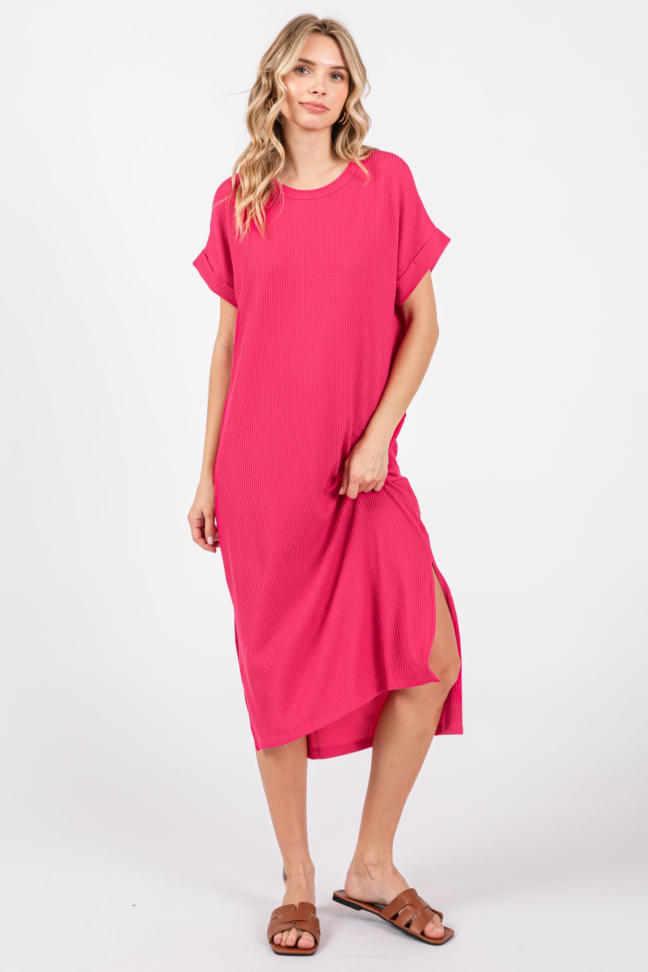 woman wearing a bright pink short sleeve midi dress with side slits and a relaxed fit