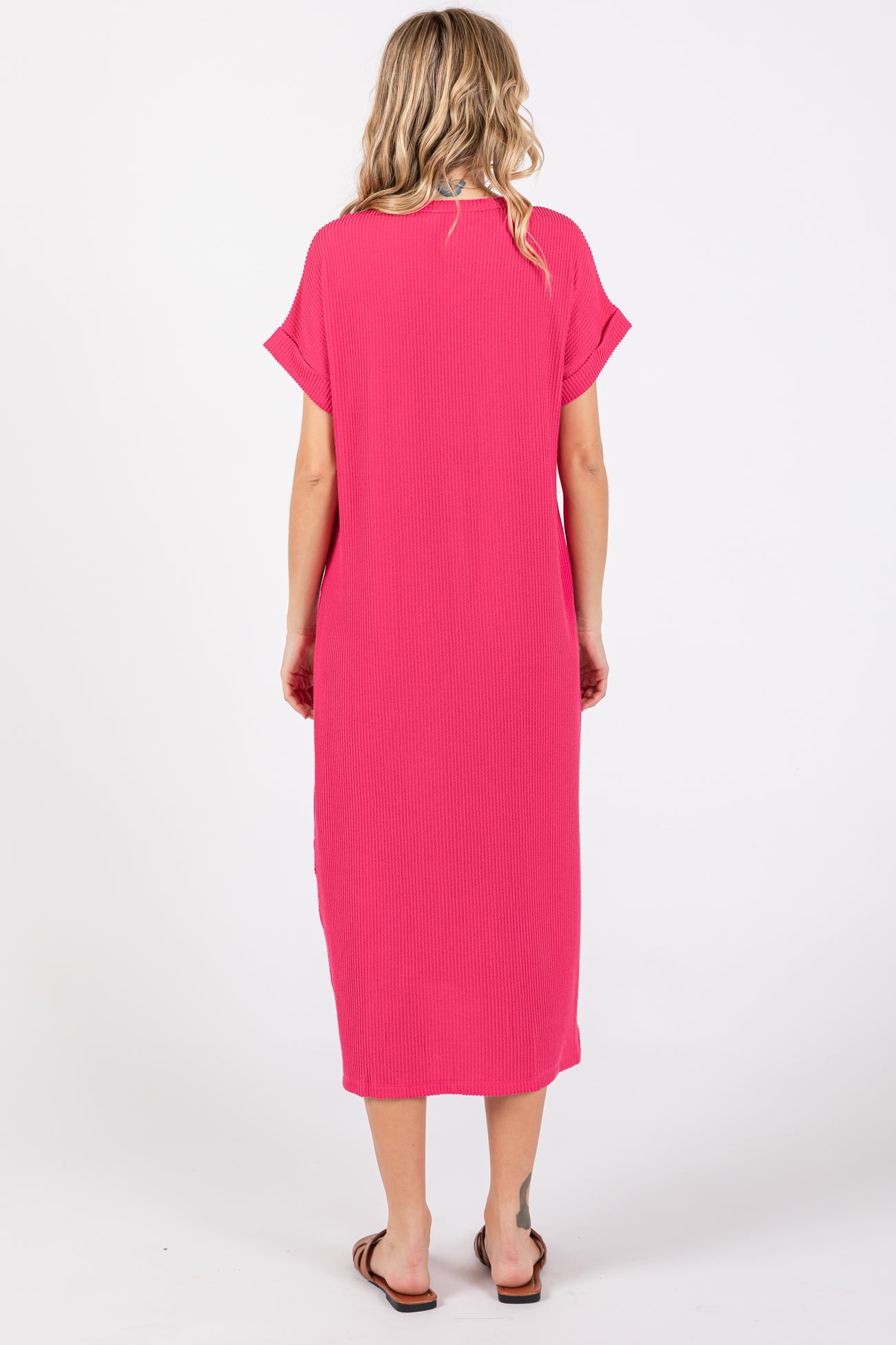 woman wearing a bright pink short sleeve maxi dress, viewed from the back