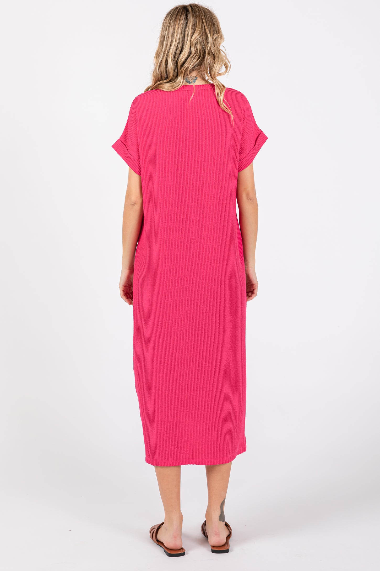 woman wearing a bright pink short sleeve maxi dress, viewed from the back