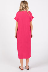 woman wearing a bright pink short sleeve maxi dress, viewed from the back