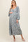 woman wearing a blue floral maternity dress with long sleeves and a baby bump visible
