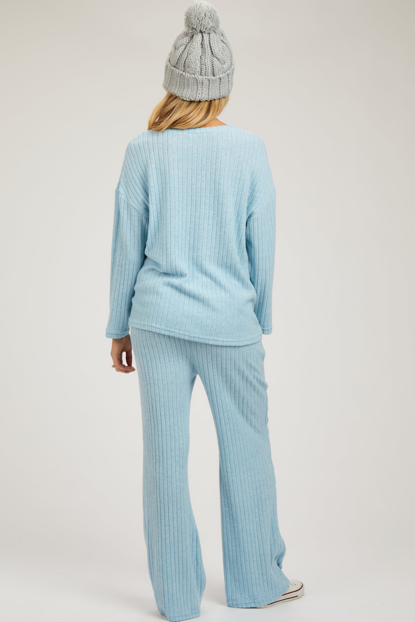 woman wearing a light blue ribbed maternity lounge set with long sleeves and wide-leg pants, showing a relaxed fit