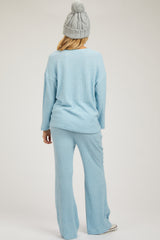 woman wearing a light blue ribbed maternity lounge set with long sleeves and wide-leg pants, showing a relaxed fit
