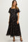 woman wearing a black floral maternity maxi dress with short flutter sleeves and a tie waist, showcasing her baby bump